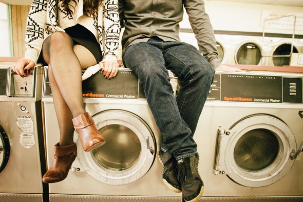 Two people sitting on a laundry machine